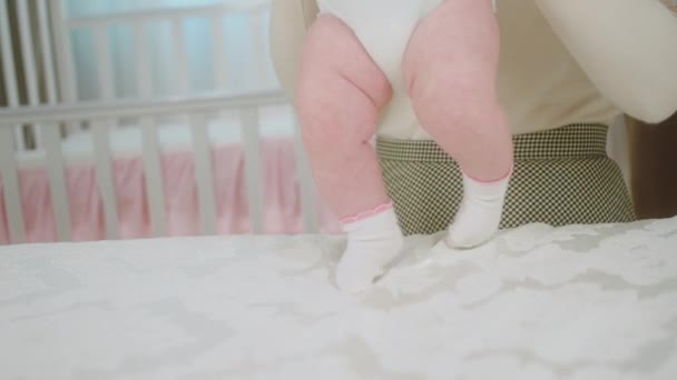 Bonita niña delante de la cámara junto con su madre pasar un buen rato juntos madre hacer ejercicio con el bebé en la cama — Vídeo de stock