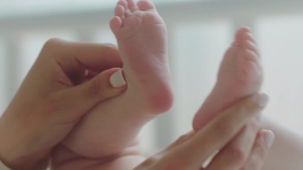 Conceito de infância na frente da câmera bonito bebê pernas mamãe jogando cuidadosamente segurando as pernas do bebê em suas mãos — Vídeo de Stock