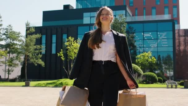 Emocionado hermosa dama delante de la cámara caminando por la calle con algunas bolsas de compras ecológicas y disfrutar del momento después de un buen día de compras — Vídeos de Stock