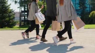 Çok ırklı bir grup öğrenci modern üniversitelerine doğru yürüyorlar ve bir şey üzerinde yoğunlaşıyorlar.