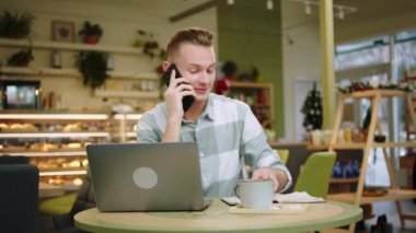 Büyük bir gülümseme ile karizmatik bir adam ara verdiğimizde modern bir kafede kahvesini içerken akıllı telefonuyla sohbet eder.