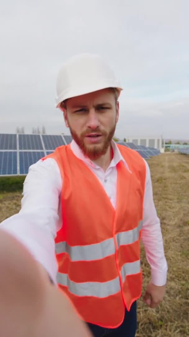 Karismatisk ekologisk ingenjör vid solkraftverk med kamera för att göra en selfie video för att beskriva situationen vid kraftverket begreppet förnybar energi och ekologisk innovation — Stockvideo