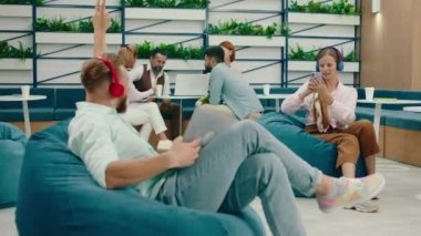 Mavi fasulye torbası üzerinde sarışın bir adam barış tabelasını tutarken başka bir sarışın kadın telefonunda onun fotoğrafını çekiyor. Arri Alexa Mini.