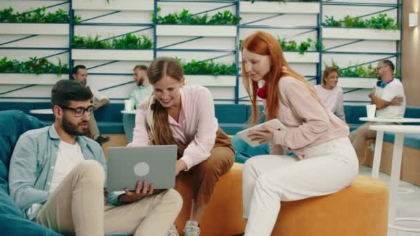 Δύο γυναίκες και ο συνάδελφός τους συζητούν για τη δουλειά, ενώ στο πίσω μέρος του άνετου γραφείου όλοι είναι απασχολημένοι. Arri Alexa Mini. — Αρχείο Βίντεο