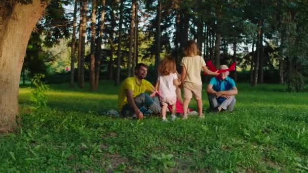 Perfekt tid tillsammans i familjen leker barn med sina föräldrar och examen med stora flygplan i mitten av parken — Stockvideo