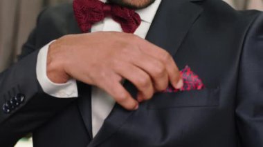 Yakından Afro-Amerikalı bir müşterinin lüks bir elbise dükkanındaki videosunu çekerken takım elbise mendillerini al ve cebine koy. Siyah özel tasarım elbisenin içinde çok iyi görünüyor.