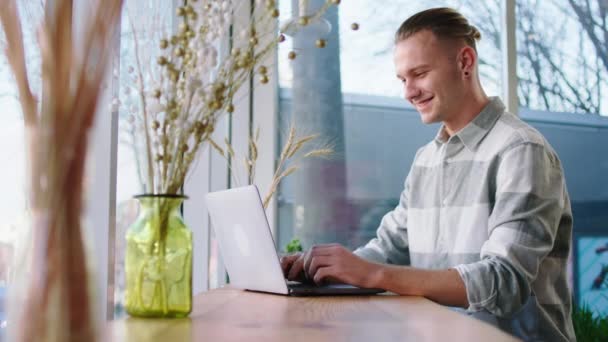 I moderna kafé karismatisk stor leende man arbetar koncentrerad på sin laptop medan sitta bredvid panoramautsikten. 4k — Stockvideo