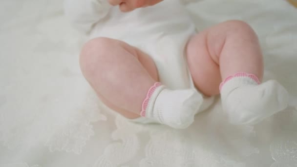 Pretty baby laying down on the bed relax time her mother playing with hands concept of maternity and childhood — Stock Video