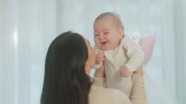 Annesi onu kucağına alıp sevgi dolu küçük kızla konuşurken büyük tatlı gülümseyen güzel bir kız çocuğu. 4k