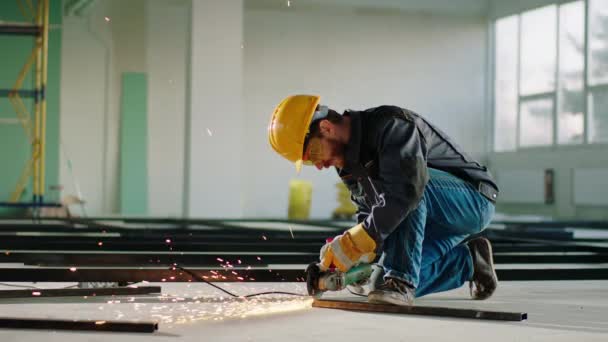 In einer Großbaustelle schneidet der fleißige Mann mit der Scheibenschweißmaschine auf der Baustelle einige Metalle — Stockvideo