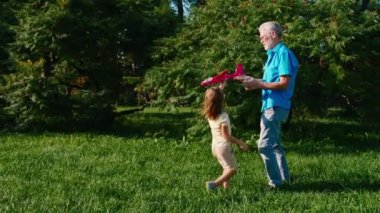 Çekici yaşlı adam ve iki sevimli yeğeni güneşli bir günde çimlerin arasında birlikte oynuyorlar.