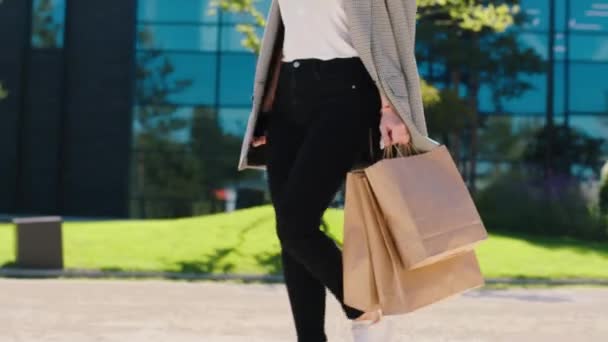 Στη μέση της σύγχρονης πόλης περπάτημα γυναίκα με κάποια eco shopping τσάντες μπροστά από την κάμερα — Αρχείο Βίντεο