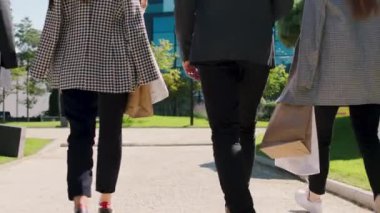 Bir grup genç ofis çalışanı öğle yemeğinden sonra ana iş merkezine doğru yürüyorlar. Birlikte yürüyorlar ve ekolojik alışveriş yapıyorlar. Video çekimleri yapıyorlar.