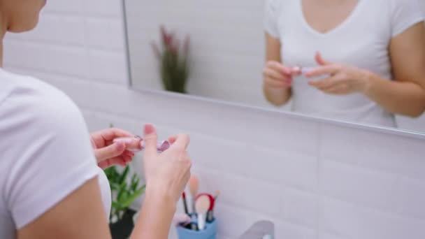 Schöne erwachsene Frau, nachdem sie im Badezimmer geduscht hat, öffnet ihren feuchtigkeitsspendenden Lippenstift und trägt ihn vorsichtig auf ihre Lippen auf — Stockvideo
