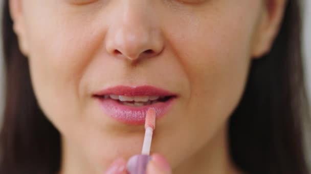 Video details nemen in de voorkant van de camera verbazingwekkende volwassen vrouw met behulp van haar favoriete lippenstift en van toepassing op haar droge lippen — Stockvideo