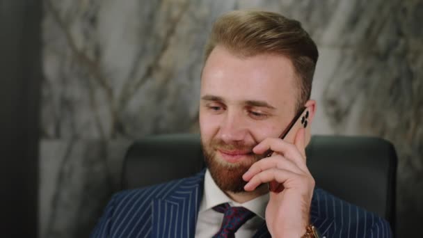 Przystojny, młody, biały biznesmen rozmawia przez telefon w biurze. — Wideo stockowe