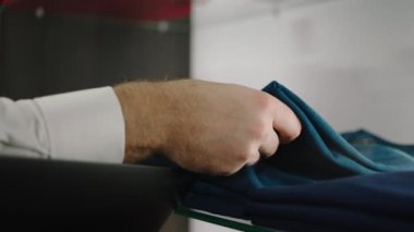 Kamera danışmanına yaklaş, kostüm dükkanı dizüstü bilgisayarını tutarken mağazadaki giysi stoğunu kontrol et.