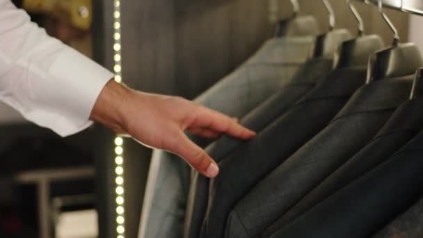 In un moderno negozio di abiti che prende video in primo piano come il cliente sceglie e guarda attraverso il nuovo concetto di collezione di abiti di design couture business e abiti fatti a mano — Video Stock