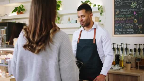 Concept van kleine bedrijven en ondernemer barista man Afro-Amerikaan hebben een gesprek met de klant op hetzelfde moment de bestelling in een gezellige coffeeshop — Stockvideo