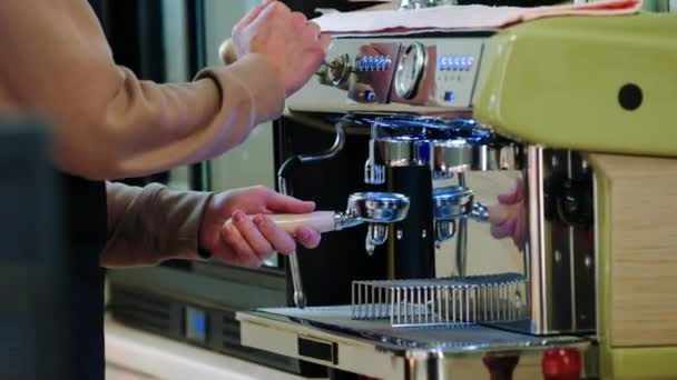 コーヒーショップでプロと現代のコーヒーマシンを使用して自然コーヒーを準備するカメラバリスタの男に近い詳細 — ストック動画