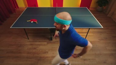 Yakışıklı beyaz tenli masa tenisi oyuncusu pinpon maçını kazandıktan sonra dans etmeye ve tuhaf davranmaya başladı.