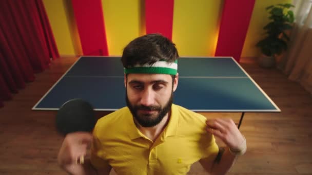 Funny ping pong player looking straight to the camera get ready to start the game then came to the ping pong table and start to play with his friend — Video