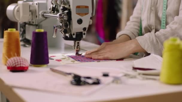 Taking details closeup of a working lady dressmaker sew some fabrics in the modern tailoring atelier on the professional sewing machine. Shot on ARRI Alexa Mini — Video Stock