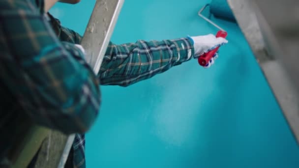 Detalles de cerca de una pintura humana las paredes en color azul usando el rodillo de cepillo de pared — Vídeos de Stock