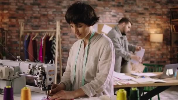 In a very calming but motivated atmosphere two tailors are working hard and getting their sewing work done — Stockvideo