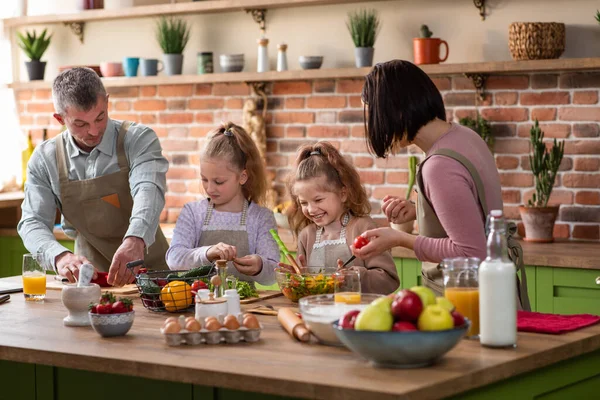 Vacker stor familj tillsammans förbereda middagen tillsammans i ett stort rymligt kök de skär några baljväxter på köksön de ler stora och glada. — Stockfoto