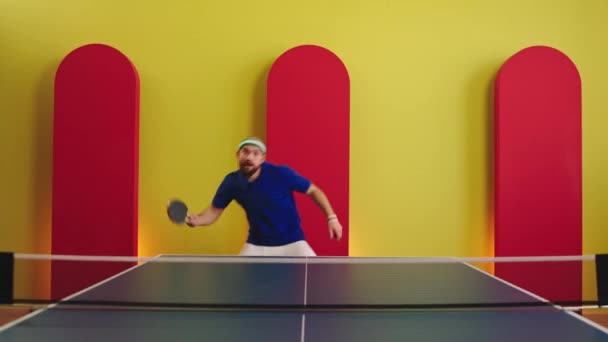 Jugador carismático bien parecido prepárate para comenzar a jugar en el ping pong que baila y se mueve ejercicio divertido antes del juego con sus paletas que son todo el equipo — Vídeos de Stock