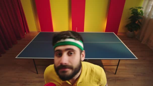 Charismatic funny ping pong player came closeup to the camera get ready to start the game then take his racket and start to playing the table tennis game — Stockvideo