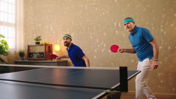 Un anciano guapo y un joven carismático jugando juntos como un equipo en el ping pong atrapan la pelota y pierden una vez y se molestan juntos — Vídeos de Stock