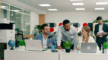 Çalışkan bir erkek ve kadın laptoplarının başında birbirleriyle konuşuyorlardı. Çok çekici melez iş arkadaşları onları kontrol etmek için ortaya çıktı. İkisi de onunla konuşuyordu.