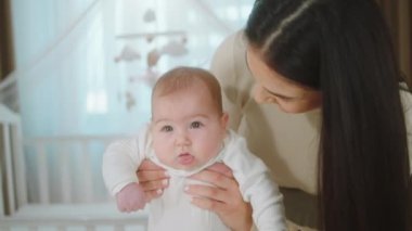 Beautiful woman young mother in the bedroom together with the baby speeding lovely time mother hugging carefully the baby concept of maternity and childhood. 4k