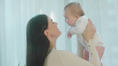 In front of the camera charismatic young mother with her baby girl speeding a perfect morning together discussing while mommy s are holding the baby in her arms. Shot on ARRI Alexa Mini.