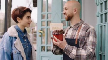 Karizmatik çiçekçi adam dükkanın dışında tartışıyor. Çiçeklerle nasıl ilgilenileceğini müşteri bayana anlatıyor. Çok tatlı.