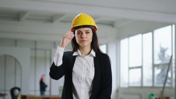 En el sitio de construcción molesta y cansada supervisora posando delante de la cámara quitarse el casco de seguridad — Vídeos de Stock