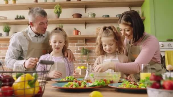 Happy kaukaska rodzina rano szczęśliwy zrobić śniadanie razem mama i tata z dwoma uroczymi dziewczynami spędzić wspaniały w kuchni — Wideo stockowe