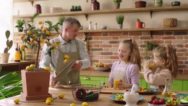 Dobrze wyglądający mężczyzna charyzmatyczny rodziny wraz z córką bawić się rano przed pójściem do pracy i szkoły przygotowują śniadanie razem tata wziąć jego patelni i mżawki jego dzieci — Wideo stockowe