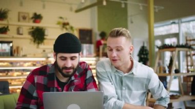 Kocaman gülümseyen iki yakışıklı öğrencinin birlikte yapacakları bir üniversite projesi var. Büyük gülüyorlar ve birlikte eğleniyorlar.