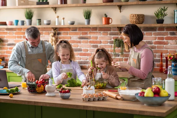 Glad vit familj på morgonen glad gör frukosten tillsammans mamma och pappa med två söta flickor tillbringa den underbara i köket. — Stockfoto