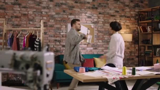 Two designers are taking a little break from work in they re home office and having a little dance party as they sing and dance together — Stockvideo