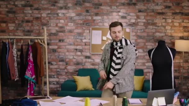 Happy excited designer guy dancing at his office while working over his new collection of clothes he enjoy the time alone — Wideo stockowe