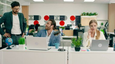 Ofiste, kısa saçlı güzel bir siyah kadın iş arkadaşına bilgisayarındaki işi soruyor, yakışıklı adam da onunla konuşurken karşılık veriyor.