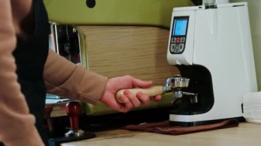 Samimi kahve barında barmen ellerini modern profesyonel kahve makinesinde doğal bir kahve hazırlıyor.