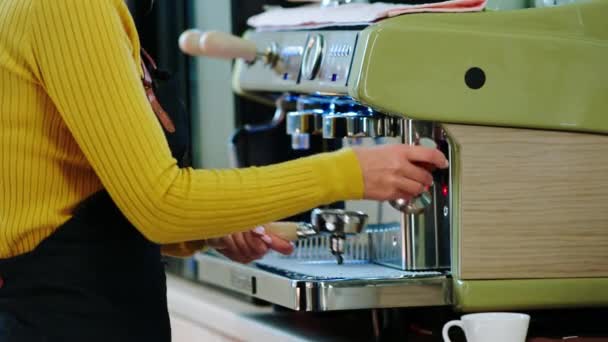 A kávéházban barista nő közelkép részletek csinál egy kávét a kávéfőző gép — Stock videók