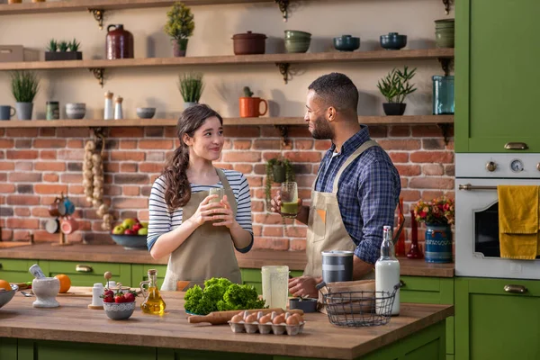 Charismatic Afro American guy and his girlfriend European looking at the kitchen island preparing the healthy breakfast together they add some fresh fruits to the blender and mix the a healthy — Φωτογραφία Αρχείου