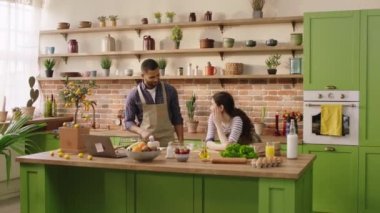 Attractive Afro American man and his partner woman cooking the dinner together and dancing together at the kitchen they enjoy the moment together. 4k