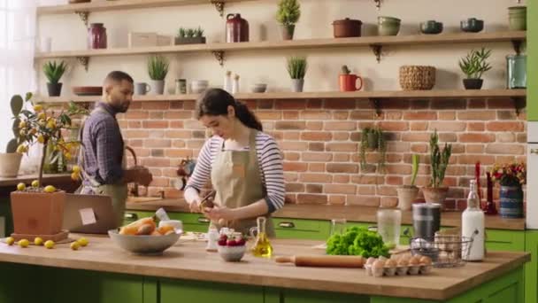 Good looking couple very lovely multiethnic in the kitchen preparing the healthy breakfast in the morning they cooking together at the kitchen island — Stockvideo